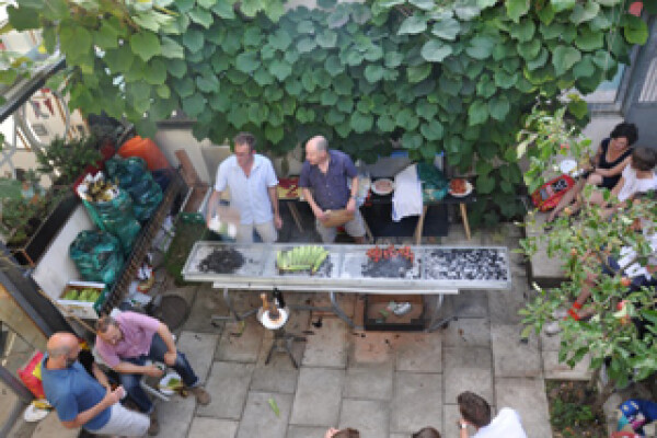 Tenth anniversary party: view from unit 4 down into front courtyard and food being grilled.