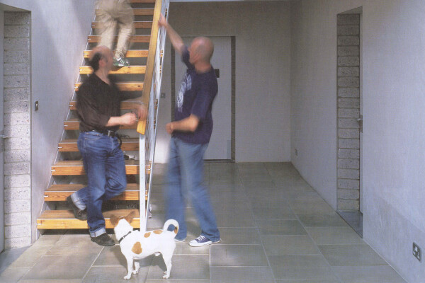 Bob (the dog), Peter, Marc and unknown at foot of stairs in a clear atrium.