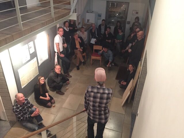 Crowd listening to man speak in an atrium.